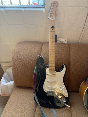 Item 4: black Fender Stratocaster with a maple neck