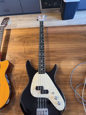 Item 6: black electric bass with a pearloid pickguard